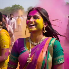 Obraz premium A happy girl in a sari at the Holi festival of multicolored colors in India.