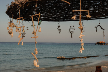 decorated sun umbrella with hanging shells at the red sea