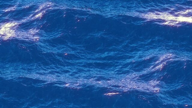 slow-motion view of the wavy sparkling ocean surface, 4k seamless loop