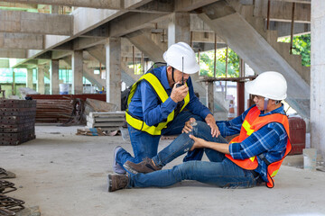 Asian factory worker having accident while working in manufacturing site while his colleague is helping for safety workplace and emergency - obrazy, fototapety, plakaty