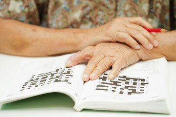 elderly woman playing sudoku puzzle game for treatment dementia prevention and Alzheimer disease.