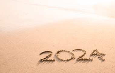 2024 year written on the beach in the sunset time. New Year 2024 concept