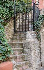 wrought iron garden gate at the top of the steep stairs
