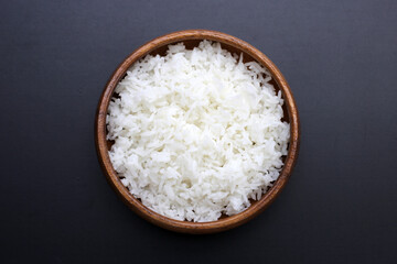 Cooked rice in bowl on dark background.