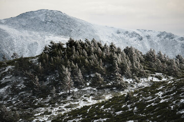 
Beautiful landscape of snowy mountains with a lake and bridge on a cloudy day in winter