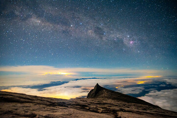 Mount Kinabalu peak with milky way galaxy with stars on a night sky background.on Mount Lowes...