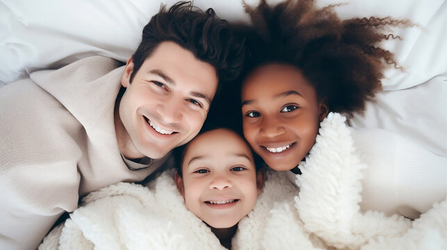 Interracial Family Having Fun Time With Mom And Dad At Bed Home Looking At The Camera