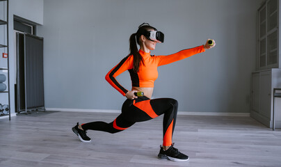 Young Woman in sportswear and virtual reality headset training with dumbbells at sport club. Fit fitness model in vr glasses training, improving endurance, muscle strength. Girl in vr googles - obrazy, fototapety, plakaty