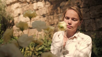 Female florist designer assembling white creamy rose bouquet composition outdoor event party closeup