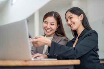 Two business colleagues talking share ideas while meeting remotely with team on laptop.