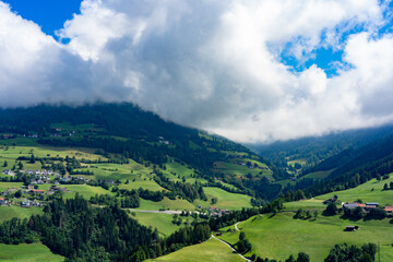 Obraz premium Blick auf die Österreichischen Berge mit Nebel Wolken und Sonne