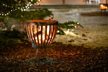 Fire pit with delightful bokeh of christmas lighting in background.Warm flames dance in the night...