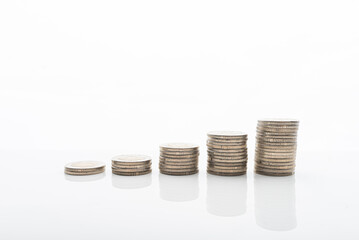 Coins stacked on white backgroud with smooth reflection. Concept of grow, investment, saving money.