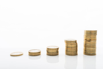 Coins stacked on white backgroud with smooth reflection. Concept of grow, investment, saving money.