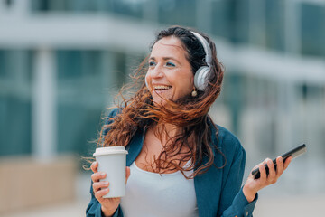 urban woman on the street with headphones - obrazy, fototapety, plakaty