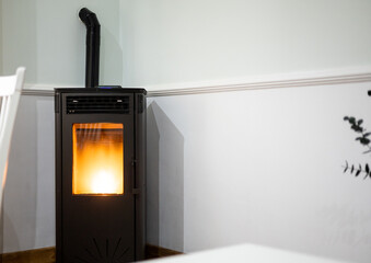 Photo of a pellet stove inside a living room of a house. Renewable energy source.biomass in pellet...