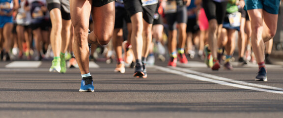 Marathon runners running on city road, large group of runners, close-up legs runners running sport...