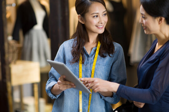 Fashion designer and customer using digital tablet