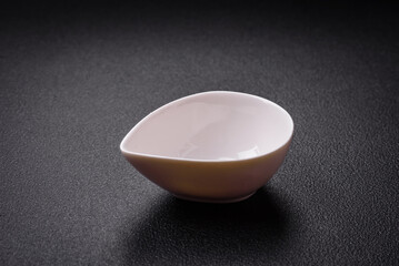 Beautiful empty white ceramic gravy boat on a textured concrete background