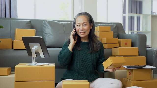 Startup small business entrepreneur or freelance using a laptop with box, checking orders from customers, matron runs an e-commerce business on websites and social media. 