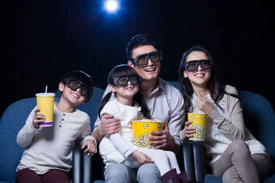 Young family watching 3D movie in cinema