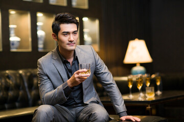 Young man drinking alcohol in luxury club