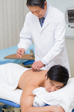 Senior doctor giving acupuncture