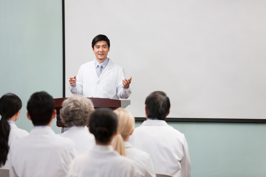 Male doctor giving speech in boardroom
