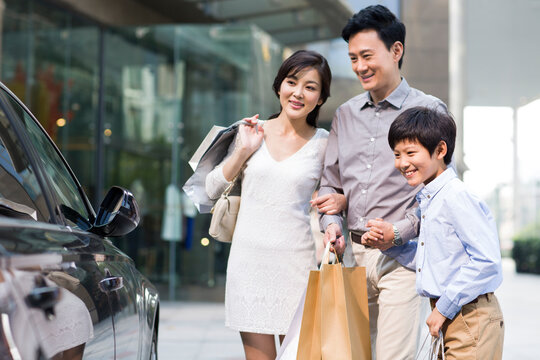 Happy family looking at a fancy car