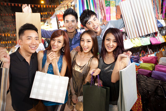 Happy young people shopping on Temple Street of Hong Kong, night view