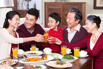 Family toasting at dinner table during Chinese New Year