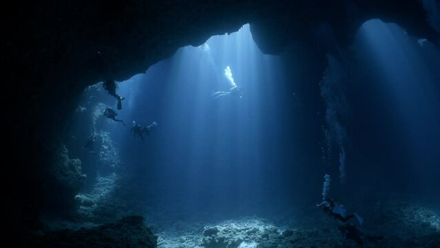 SCUBA Divers explore a large underwater cavern