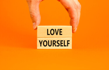 Love yourself symbol. Concept words Love yourself on beautiful wooden blocks. Beautiful orange table orange background. Businessman hand. Psychology love yourself concept. Copy space. - obrazy, fototapety, plakaty