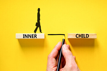 Inner child symbol. Concept words Inner child on beautiful wooden block. Beautiful yellow table yellow background. Psychologist hand. Psychological, motivational inner child concept. Copy space.