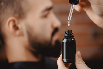 Oil for beard in dropper, process of moisturizing skin, cosmetic for growth hair of man