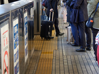 冬の新幹線のホームの電車待ちの人々の姿