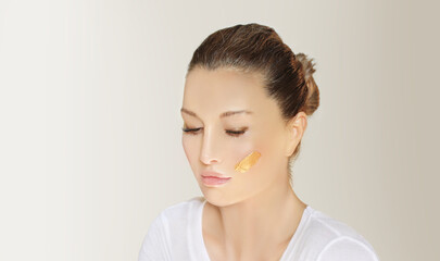 Obraz na płótnie Canvas woman applying serum, lotion to her face