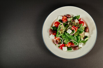 top view photo of plate with freshly made delicious Greek salad on grey background, healthy eating