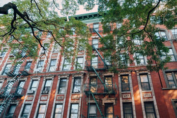 Facade of a typical New York block of flats with fire escape at the front, USA. © Alena