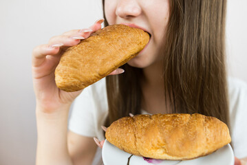 Close-up photo of a woman eating a croissant