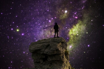 silhouette of a person in on the top of the mountain with galaxy space
