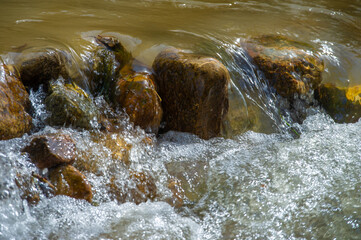 Serene waters flowing through rocky obstacles create a harmonious symphony of nature's resilience....