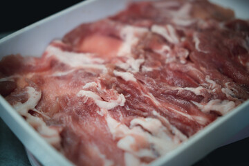 Raw beef used for sukiyaki and shabu in white tray. Close up