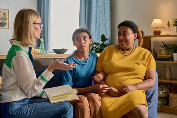Social worker talking to African American adoptive family during their meeting at home