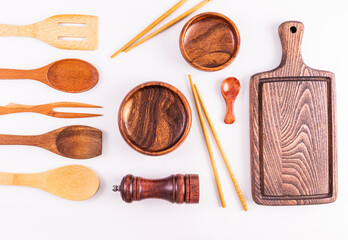 Empty wooden bowls, sushi sticks, cutting kitchen board and various wooden kitchen utensils on...