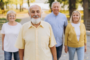 Portrait of old man with gray beard against the background of a group of old people