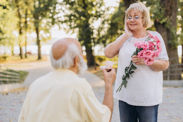 Senior Gentleman Making Proposal To Happy Excited Lady Outdoors