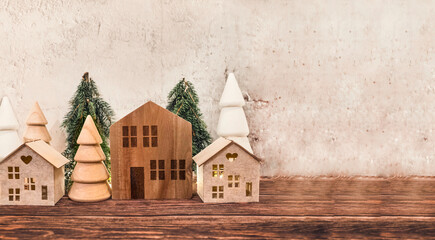 Christmas decoration with wooden small houses in Scandinavian style and Wooden Pine trees