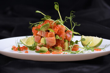 Avocado tartare with salmon, red caviar and pea sprouts.