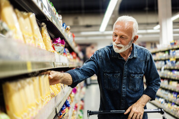 Retired man buying groceries. Mature Male Buyer Shopping Groceries in Supermarket.